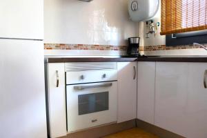 a kitchen with white cabinets and an oven at Mi UNIVERSO in San Fernando