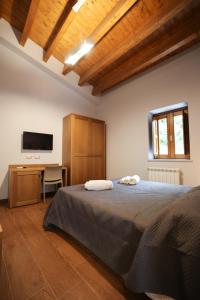 Dormitorio con cama, escritorio y TV en Camere U Campanaru, en Gratteri