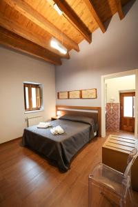 1 dormitorio con 1 cama en una habitación con techos de madera en Camere U Campanaru, en Gratteri