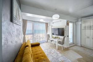 a living room with a couch and a table at Magic Studio in Infinity Beach Resort Pool & Parking in Mamaia