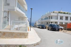 a street with cars parked next to a building at Indiveri holiday apartaments Melissa by STHEY in Polignano a Mare
