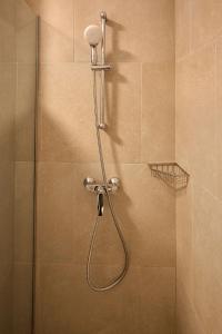 a shower with a shower head in a bathroom at Magic Studio in Infinity Beach Resort Pool & Parking in Mamaia