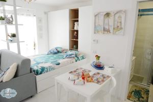 a white room with a bed and a table at Indiveri holiday apartaments Melissa by STHEY in Polignano a Mare