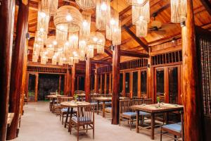 a dining room with tables and chandeliers at Natalie's Villa & Resort in Mộc Châu