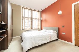 a bedroom with an orange wall and a bed at Alton Chambers in Parkstone
