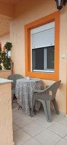 a table and chairs on a patio with a window at Despoina Apartments in Keratokampos