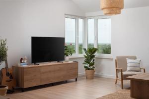 - un salon avec une télévision à écran plat sur une armoire en bois dans l'établissement Spacious and fully equipped apartment near Zadar, à Smoković