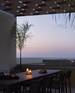 a table with candles and a tree in a room at Mela Villas in Maroulás