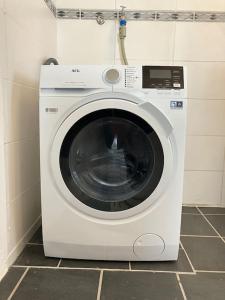 a white washing machine sitting in a bathroom at Großes Ferienhaus in Singhofen in Singhofen