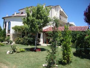 a large house with trees in front of a yard at APARTMAN LUCIA in Ražanac