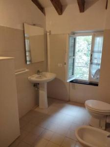 a bathroom with a sink and a toilet and a window at Casa dell'Arco 31 in Camogli