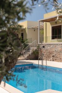 a swimming pool in front of a house at Mela Villas in Maroulás