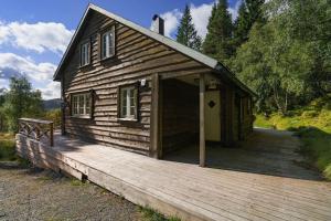 Tjørhom的住宿－Koselig hytte med sjel på fjellet :)，小木屋设有门廊和木甲板