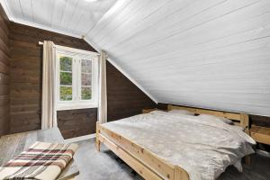 Tjørhom的住宿－Koselig hytte med sjel på fjellet :)，一间卧室设有一张床和一个窗口