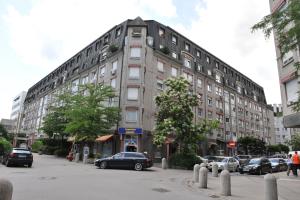 a large building with cars parked in front of it at Apartment Zala with free parking Tour As Ljubljana in Ljubljana