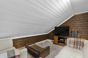 Una sala de estar con un sofá y un televisor. en Koselig hytte med sjel på fjellet :), en Tjørhom