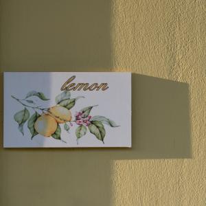 a sign on a wall with lemons on it at Mela Villas in Maroulás