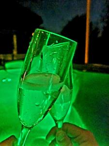 a person holding a glass of water on a table at Kuća za odmor Malia sa Spa Hot Tub Jacuzzijem - Nice and Cozy in Ðurđevac