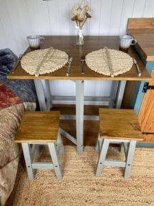 een houten tafel met twee banken en een tafel met twee stoelen bij Bexhill Old Town Retreat in Bexhill