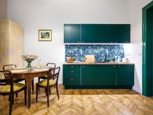 une cuisine avec des placards verts et une table avec des chaises dans l'établissement Tyzenhauz Apartments Lobzowska Street, à Cracovie