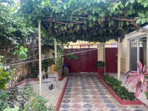 a pergola with a red door in a garden at CHEZ CODOU Fann Hock in Dakar