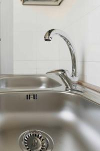 - un évier de cuisine avec un robinet et un robinet dans l'établissement Casa Vacanze Iris (Baia Verde), à Baia Verde
