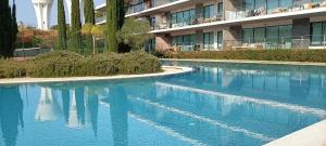 a swimming pool with blue water in front of a building at RESIDENCE GOLF CLUB 415 in Quarteira