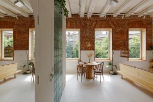 a room with a table and chairs and windows at Loft Apartment in Ivano-Frankivsʼk
