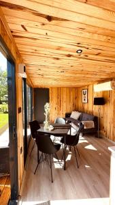 a patio with a table and chairs and a couch at Luxe Tiny House bij het Leekstermeer in Matsloot