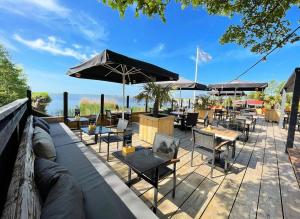 a patio with tables and chairs and umbrellas at Cozy Tiny House bij het Leekstermeer in Matsloot