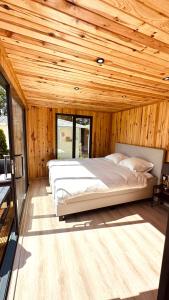 a bedroom with a large bed in a wooden ceiling at Luxe Tiny House bij het Leekstermeer in Matsloot