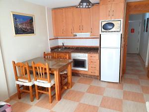 eine Küche mit einem Tisch und Stühlen sowie einem Kühlschrank in der Unterkunft One bedroom in Benidorm Playmon Park in Benidorm