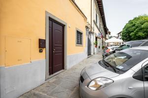 ein silbernes Auto, das auf einer Straße neben einer Tür parkt in der Unterkunft Settignano Quiet Apartment with Private Parking in Settignano