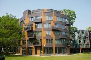 un edificio de apartamentos alto con ventanas y árboles en 2 Bedroom Apt, 2 Garage Spots & Balconies, Self Check-in, by Cohost, en Druskininkai