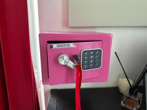 a pink pay phone with a red ribbon attached at A4 in Savona
