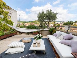 a patio with a white couch and a hammock at Loft Bouquet Alella mar y montaña 25 min a BCN in Alella