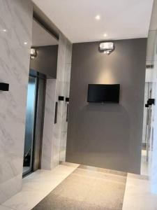 ein Bad mit einem Flachbild-TV an der Wand in der Unterkunft Pasig Condo FAST WIFI with Netflix and Pool Access in Manila