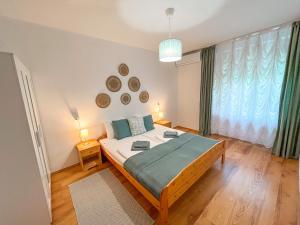 a bedroom with a large bed and a large window at BDCSNY Apartman in Badacsonytördemic