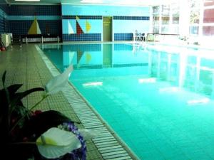 a large swimming pool with blue water in a building at Fewo 91 WHG B 1 in Burhave in Burhave