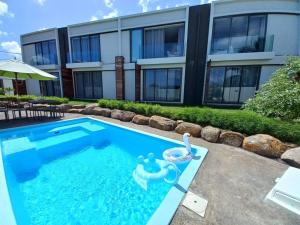 a swimming pool with a toy in front of a building at Bois Mapou Self Catering Apartments Unit 202 in Rivière Noire