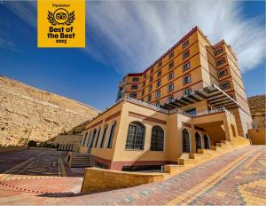 un edificio con una señal que lee atrás de lo mejor en Petra Canyon Hotel en Wadi Musa