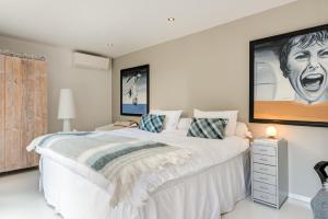 a bedroom with a large white bed with a picture on the wall at Villa Modern Bergen in Bergen