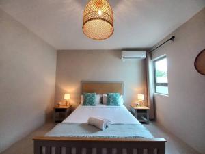 - une chambre avec un lit avec deux tables et une lampe dans l'établissement Bois Mapou Self Catering Apartments Unit 202, à Rivière Noire
