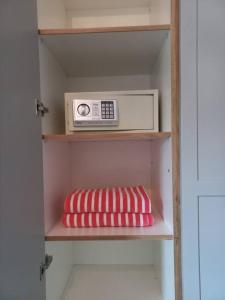 - une étagère avec un four micro-ondes et un oreiller dans l'établissement Bois Mapou Self Catering Apartments Unit 202, à Rivière Noire
