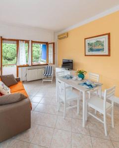 ein Wohnzimmer mit einem Tisch und Stühlen in der Unterkunft Ambra Marina, la casa tra i pini a Rapallo! in Rapallo