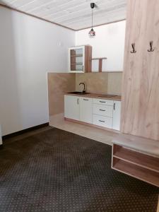 a kitchen with white cabinets and a sink at Apartamenty Polańczyk in Polańczyk