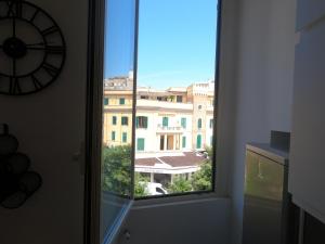 una finestra in una camera con vista su un edificio di La Mansarda al Borghetto a Nettuno