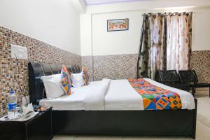 FabHotel Prime Wonder World Resort في دارامشالا: غرفة نوم بسرير وطاولة ونافذة