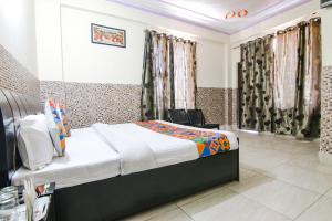 1 dormitorio con 1 cama y 1 silla en FabHotel Prime Wonder World Resort, en Dharamshala