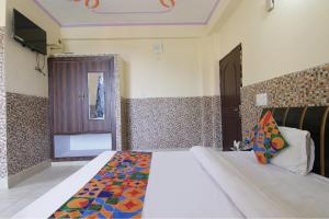 a bedroom with a large bed with a colorful comforter at FabHotel Prime Wonder World Resort in Dharamshala